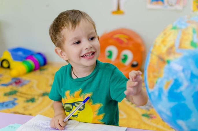 A child looking at a globus